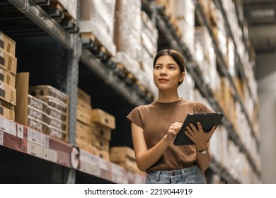 Young female manager worker checklist manage parcel box product in warehouse. Asian woman supervisor using tablet working at store industry. Logistic import export concept. - Powered by Shutterstock