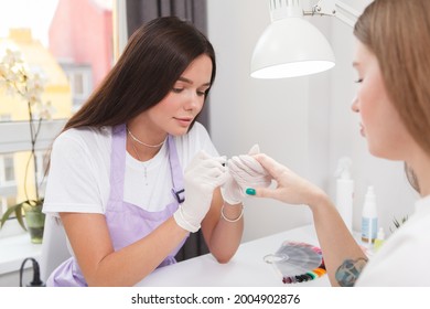 Young female manicurist doing nails of female client - Powered by Shutterstock