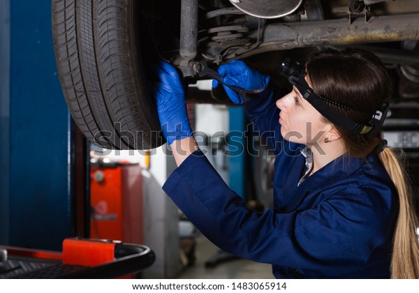 Young female master is repairing car in\
workshop at\
workplace\
\
\
