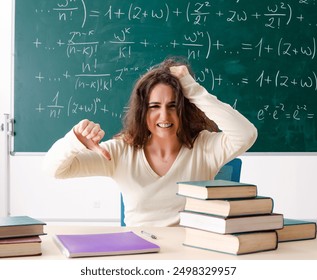 Young female math teacher in front of chalkboard - Powered by Shutterstock