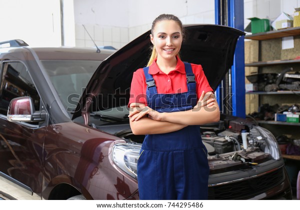 Young female mechanic in\
body shop