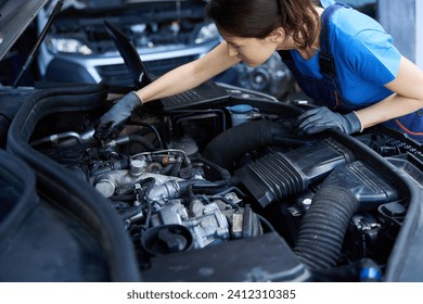 Young female mechanic repairs a car at service station - Powered by Shutterstock