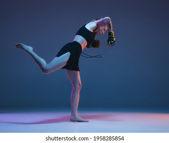 Young female MMA fighter training isolated over blue background in neon light - Shutterstock ID 1958285854