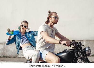 Young female model holding skateboard. Young man and woman having fun on a sunny day