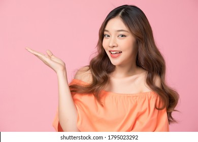 Young female model posing happy gesture, isolated on pink background