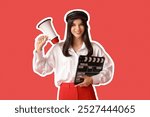 Young female movie director with clapperboard and megaphone on red background