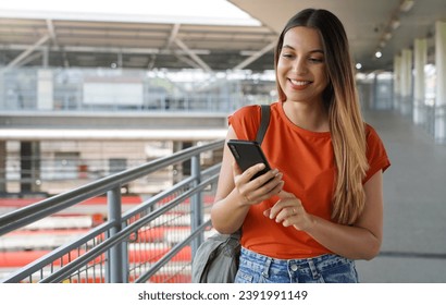 A young female multi ethinc businesswoman uses a mobile phone searches for information, writes a message, outdoors - Powered by Shutterstock