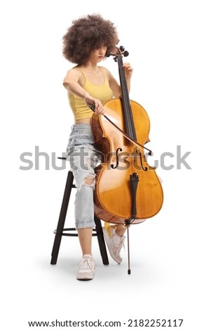 Young female musician sitting on a chair and playing a contrabass isolated on white background