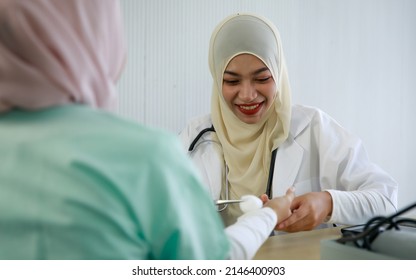 Young Female Muslim Doctor Cleaning Patient's Wrist Using Cotton Swap With Alcohol And Preparing For A Vaccine Shot.