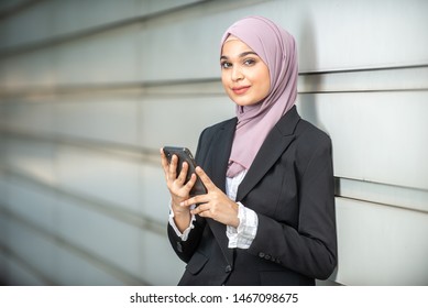 Young Female Muslim Entrepreneur And Her Smartphone. Shallow Depth Of Field.