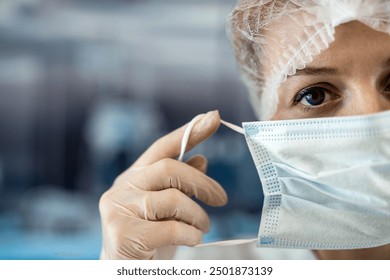 young female nurse putting her medical mask at surgery. Healthcare worker - Powered by Shutterstock