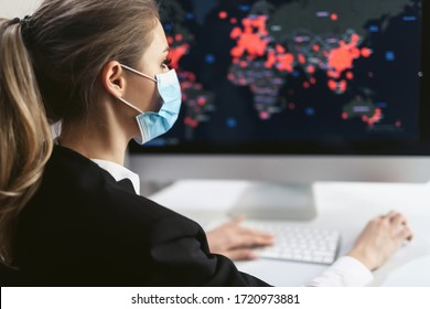 Young Female Office Worker Is Shocked By The Spread Of The Coronavirus Epidemic. Map Of The Covid 19 Pandemic Worldwide. Girl In A Disposable Medical Facial Mask