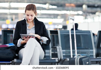 Young female passenger at the airport, using her tablet computer while waiting for her flight (color toned image) - Powered by Shutterstock