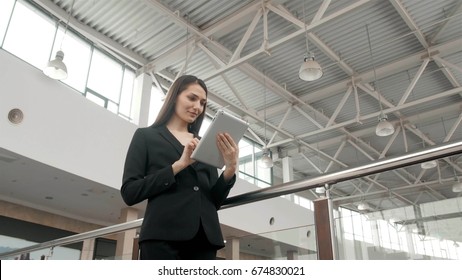 Young Female Passenger Traveller At The Airport Using Her Tablet Computer While Waiting For Flight, Business Woman After Work In Office In Shopping Mall Use Tablet Pc