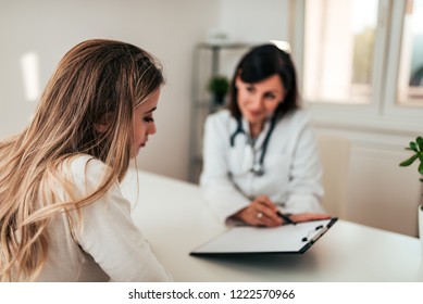 Young female patient listening to her doctor. - Shutterstock ID 1222570966