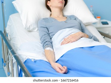 Young female patient lying in bed with IV drip, medicine and treatment concept - Powered by Shutterstock