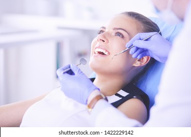 Young Female Patient With Open Mouth Examining Dental Inspection At Dentist Office.