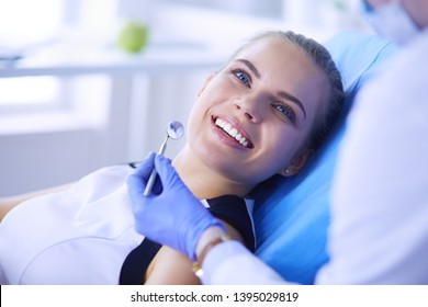 Young Female patient with pretty smile examining dental inspection at dentist office. Coronavirus COVID-19 virus pandemic