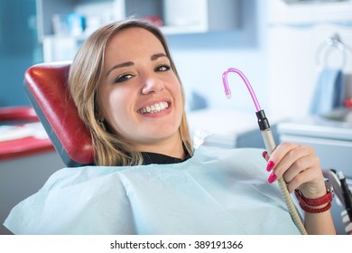 Young Female Patient Smiling And Holding Suction Tube. 