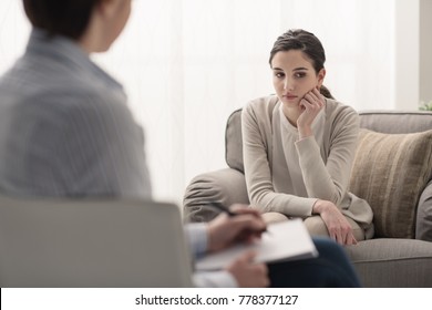 Young female patient talking with her therapist in the office, mental health and psychotherapy concept
