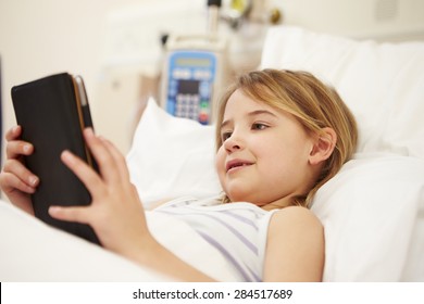 Young Female Patient Using Digital Tablet In Hospital Bed