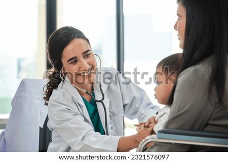 Young female pediatric doctor teases little Asian boy before medical examination at outpatient clinic hospital, people public health care checkups, and appointment visits.