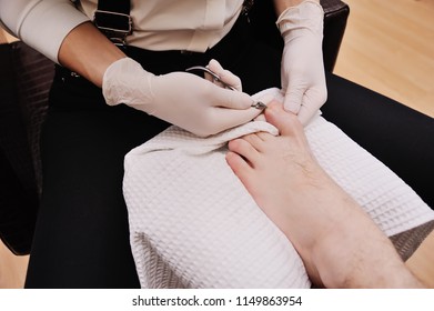 Young Female Pedicure Master Doing Finger Nail Care Customer Men On Spa Salon Background