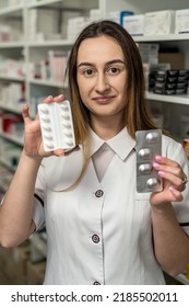 A Young Female Pharmacist Reads Medicine Instructions While Standing In The Chemist's Aisle. Pharmacy. Pharmacist. Medicine. Tablets