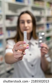 A Young Female Pharmacist Reads Medicine Instructions While Standing In The Chemist's Aisle. Pharmacy. Pharmacist. Medicine. Tablets