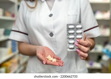 A Young Female Pharmacist Reads Medicine Instructions While Standing In The Chemist's Aisle. Pharmacy. Pharmacist. Medicine. Tablets