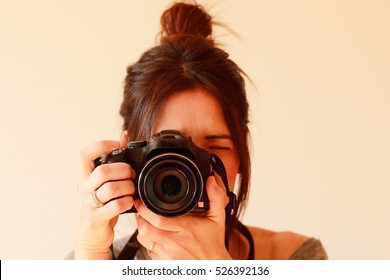 Young Female Photographer With Camera On Soft Background Taking A Picture With Her New Camera
