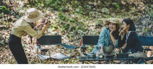 Young Female Photographer Enjoy To Take Photo Her Friends, She Use Digital Camera And Lovely Girl Pose At Camping Tent In Nature Forest, Copy Space