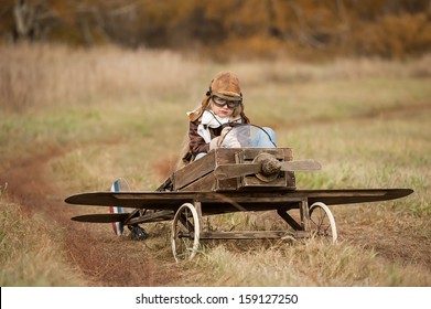 Young female pilot in a homemade plane in a field on a sunny autumn day
