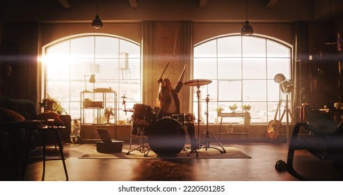 Young Female Playing Drums During a Band Rehearsal in a Loft Studio with Warm Sunlight at Daytime. Drummer Girl Practising Before a Live Concert on Stage. Talented Musician Enjoying Music. - Powered by Shutterstock