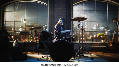 Young Female Playing Drums During a Band Rehearsal in a Loft Studio During an Evening or Night Session. Drummer Girl Practising Before a Live Concert on Big Stage with Audience. - Powered by Shutterstock