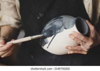 Young female potter glazing clay vase, traditional pottery making - Powered by Shutterstock