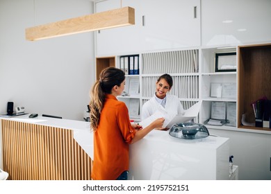 Young female practitioner or nurse working at clinic reception desk.	 - Powered by Shutterstock