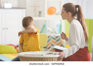 Young female psychologist working with little boy in office - Shutterstock ID 569946964