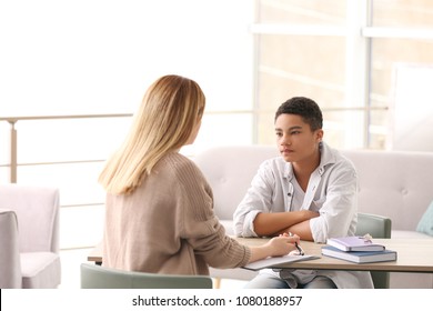 Young Female Psychologist Working With Teenage Boy In Office