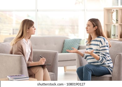 Young Female Psychologist Working With Teenage Girl In Office