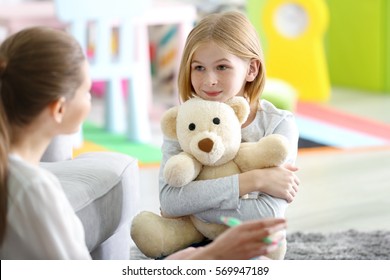 Young female psychologist working with teenager girl in office - Shutterstock ID 569947189