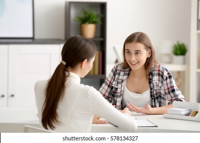 Young Female Psychologist Working With Teenager Girl In Office