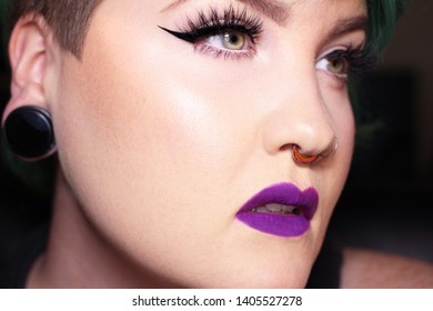 Young Female With Purple Lipstick, Winged Eyeliner And Long Lashes