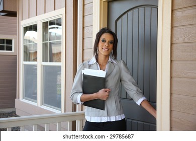 Young Female Realtor Opening Front Door Of Home