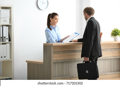 Young Female Receptionist Meeting Client In Office