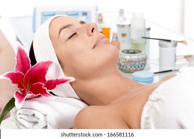 Young female relaxing eyes closed in beauty parlour, receiving treatment.