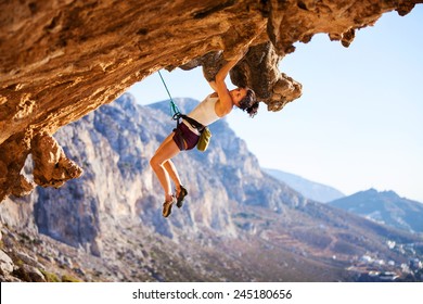 Young Female Rock Climber On A Cliff 