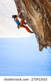 Young Female Rock Climber On A Cliff