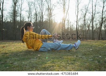Young female runner doing warm up sit ups