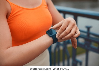 Young female runner using smart watch to monitor her performance. 